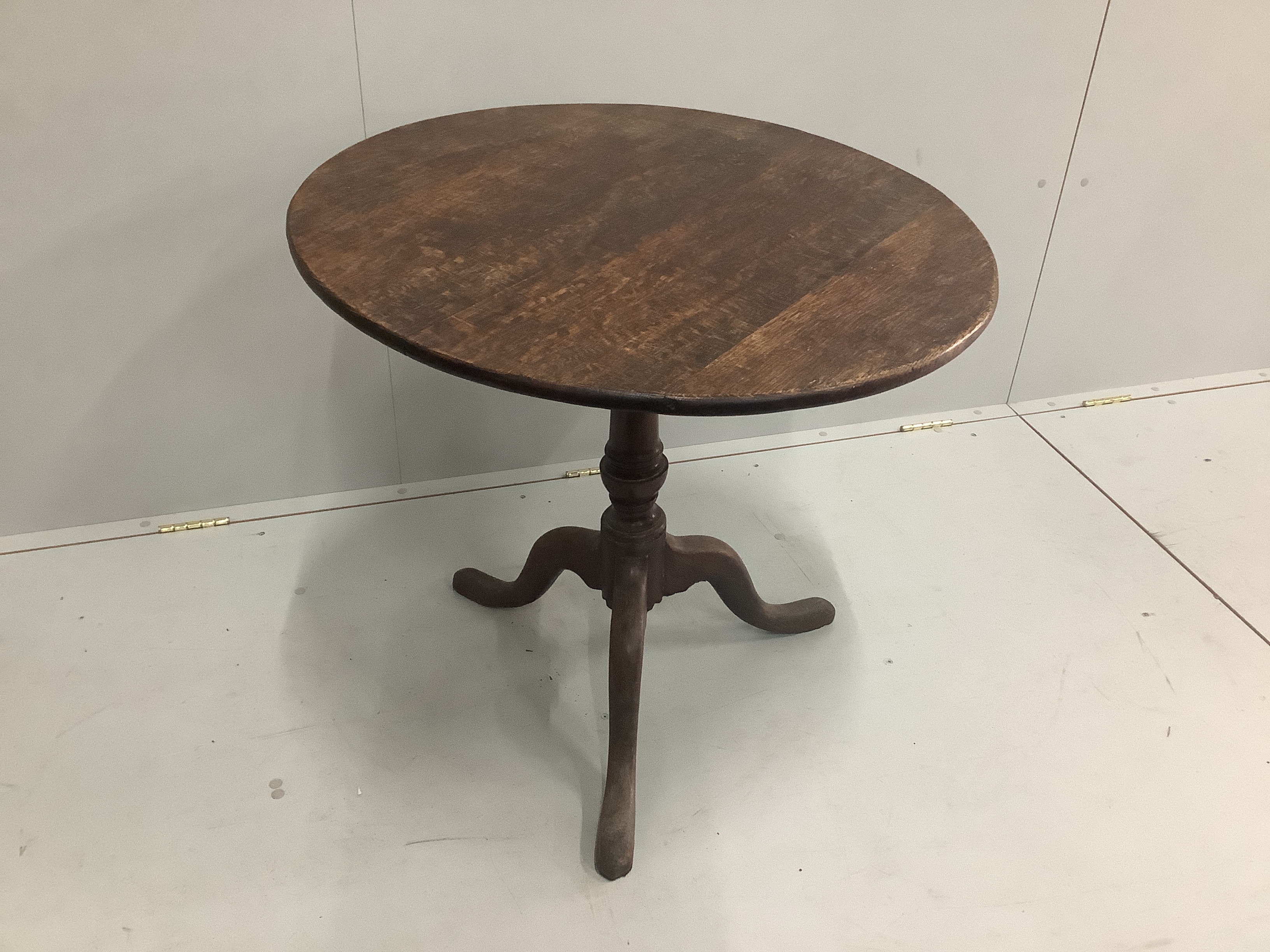 A George III circular oak tilt top tripod tea table, diameter 75cm, height 70cm